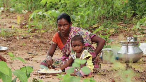 A tribal woman having a meal with her child